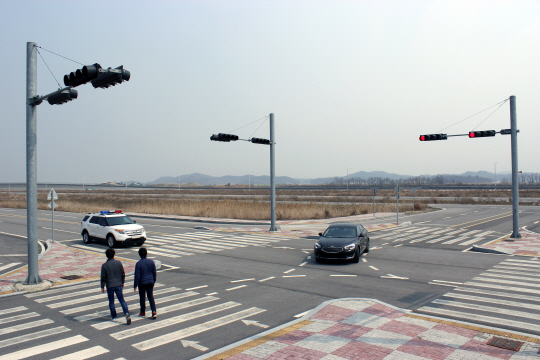 자율주행차가 교차로에서 V2I(차량 대 교통시설물) 통신과 카메라 센서 등을 이용해 좌회전 신호를 인식하고 좌회전 하고 있다.